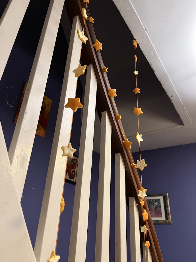 Several completed orange garlands hang from the stairs.